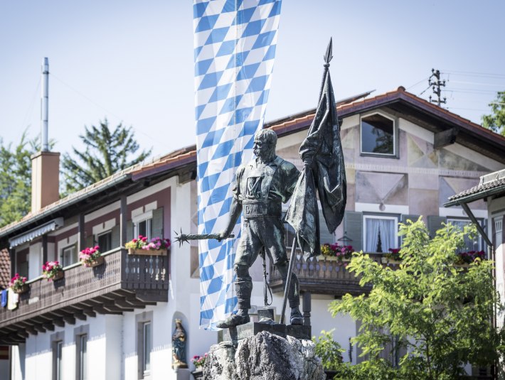 Die Statue Schmid von Kochel am Schmied von Kochel Platz in Kochel am See, © Tourist Information Kochel a. See